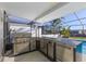 This is an outdoor kitchen with stainless steel appliances that is poolside at 8716 Hickorywood Ln, Tampa, FL 33615