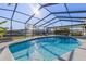 Sparkling screened-in pool basks in the sun, surrounded by a lush backyard and serene waterfront views at 8716 Hickorywood Ln, Tampa, FL 33615