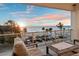 This balcony features comfortable seating and a table with views over the beach and the ocean at 8750 Harrell Ave, Treasure Island, FL 33706