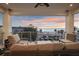 This balcony features comfortable seating and a table with sunset views over the beach at 8750 Harrell Ave, Treasure Island, FL 33706