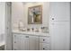 Bathroom with vanity, white cabinets, quartz countertop, and framed mirror at 8750 Harrell Ave, Treasure Island, FL 33706