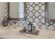 Stylish bathroom featuring a decorative backsplash, dual mirrors, and a marble countertop with elegant fixtures at 8750 Harrell Ave, Treasure Island, FL 33706