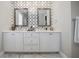 A double vanity bathroom features a white marble countertop, white cabinets, and decorative patterned backsplash at 8750 Harrell Ave, Treasure Island, FL 33706