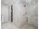 A clear glass shower features white tile and a storage closet with a white door and marble floor at 8750 Harrell Ave, Treasure Island, FL 33706