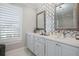 Stylish bathroom featuring dual sinks, marble counters, and patterned tile accent wall at 8750 Harrell Ave, Treasure Island, FL 33706