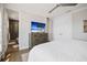 This modern bedroom showcases a sleek dresser, serene beach view on the TV and access to en suite bath at 8750 Harrell Ave, Treasure Island, FL 33706