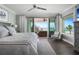 This bedroom features a beach view, ceiling fan, balcony access, hardwood floors, and beachy color palate at 8750 Harrell Ave, Treasure Island, FL 33706