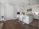 Bright kitchen features white cabinets, marble counters, large island, pendant lights, and stainless appliances at 8750 Harrell Ave, Treasure Island, FL 33706