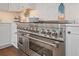 The bright kitchen has stainless steel appliances with white cabinets and marble countertops at 8750 Harrell Ave, Treasure Island, FL 33706