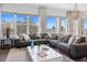 Relaxing living room with a gray sectional, large windows showcasing ocean views, and stylish coastal-inspired decor at 8750 Harrell Ave, Treasure Island, FL 33706