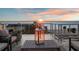 Enjoy breathtaking sunsets from this rooftop deck with comfortable seating, lanterns, and serene ocean views at 8750 Harrell Ave, Treasure Island, FL 33706