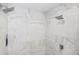 Contemporary shower featuring dual shower heads and sleek white marble tiling at 8750 Harrell Ave, Treasure Island, FL 33706