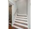 Staircase with hardwood steps leading up to the next level and bathroom with glass enclosed shower at 8750 Harrell Ave, Treasure Island, FL 33706