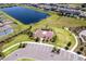 Aerial view of a modern community featuring a pond, basketball court and lush landscaping at 16719 Delia St, Wimauma, FL 33598