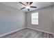 This bedroom features gray walls, laminate wood flooring, a ceiling fan, and a window with blinds at 16719 Delia St, Wimauma, FL 33598