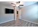 This bedroom features stylish gray wood flooring and a ceiling fan with a light fixture at 16719 Delia St, Wimauma, FL 33598