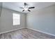 Light-filled bedroom featuring gray wood floors, a ceiling fan, and a window with a blind at 16719 Delia St, Wimauma, FL 33598