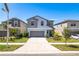 Beautiful two-story home with gray accents, a two-car garage, and landscaped front yard at 16719 Delia St, Wimauma, FL 33598