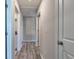 Hallway featuring wood-look flooring, neutral walls, and multiple entryways at 16719 Delia St, Wimauma, FL 33598