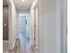 Bright hallway showcasing modern gray wood floors and multiple doors leading to various rooms at 16719 Delia St, Wimauma, FL 33598