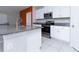 Modern kitchen featuring granite countertops, stainless steel appliances, and white cabinets at 16719 Delia St, Wimauma, FL 33598