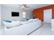 Modern living room with a large white couch, ceiling fan, mounted tv, and accent wall at 16719 Delia St, Wimauma, FL 33598