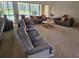 Spacious living room with large windows overlooking the pool, offering comfortable seating arrangements at 2280 Toniwood Ln, Palm Harbor, FL 34685