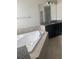 Large soaking tub and vanity with granite countertops and black cabinets in primary bathroom at 2588 Bartolo Dr, Land O Lakes, FL 34639