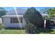 Exterior view of the home is showcased with mature landscaping and a 'For Sale' sign out front at 509 Rosery Nw Rd, Largo, FL 33770