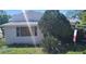The home's exterior is showcased with mature landscaping and a 'For Sale' sign out front at 509 Rosery Nw Rd, Largo, FL 33770