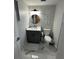 Cozy bathroom with a modern vanity, round mirror, and a toilet near small wall decor at 6220 Westport Dr, Port Richey, FL 34668