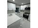 Clean, modern kitchen featuring white countertops, stainless steel appliances, and ample lighting at 6220 Westport Dr, Port Richey, FL 34668