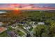 Stunning aerial view of a home nestled amidst lush greenery and a beautiful sunset on the horizon at 7876 Marsh Pointe Dr, Tampa, FL 33635