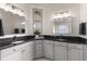 Stylish bathroom featuring dual sinks, dark countertops, white cabinets, and framed mirrors at 7876 Marsh Pointe Dr, Tampa, FL 33635