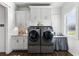 Bright laundry room features modern appliances, cabinets, sink, and stylish backsplash at 7876 Marsh Pointe Dr, Tampa, FL 33635