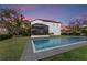 A backyard pool surrounded by lush green grass and an enclosed patio that offers a relaxing and private outdoor space at 7876 Marsh Pointe Dr, Tampa, FL 33635
