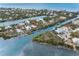 Aerial view of a waterfront home in a coastal community, surrounded by lush greenery and waterways at 79 Palm Dr, Placida, FL 33946