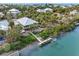 Aerial view of a waterfront home with a private dock surrounded by lush greenery and stunning water views at 79 Palm Dr, Placida, FL 33946