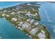 Aerial view of a waterfront neighborhood, showcasing homes along canals and the open bay at 79 Palm Dr, Placida, FL 33946
