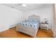 Bedroom with light hardwood floors, a ceiling fan, two side tables, and white trim at 79 Palm Dr, Placida, FL 33946