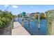 Private boat lift with wood dock overlooking serene waterfront and beautiful home in the background at 79 Palm Dr, Placida, FL 33946
