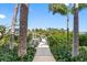 Picturesque pathway leading to a private dock, surrounded by lush greenery and palm trees at 79 Palm Dr, Placida, FL 33946