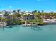 Inviting waterfront home featuring a private dock, lush landscaping, and clear turquoise waters at 79 Palm Dr, Placida, FL 33946