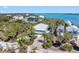 Waterfront home with a metal roof and a paver driveway surrounded by mature tropical landscaping at 79 Palm Dr, Placida, FL 33946