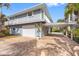 The house features a brick driveway, a carport, a two-car garage, and an upstairs balcony at 79 Palm Dr, Placida, FL 33946