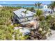Stunning coastal home with lush landscaping, complemented by a metal roof and scenic water views at 79 Palm Dr, Placida, FL 33946
