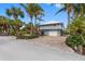 Beautiful two-story house with a brick driveway, two-car garage, lush landscaping, and a beachy aesthetic at 79 Palm Dr, Placida, FL 33946