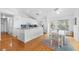 Bright kitchen with white cabinetry, stainless appliances, a breakfast bar and adjacent dining area with natural light at 79 Palm Dr, Placida, FL 33946
