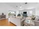 Bright living room with hardwood floors, neutral furnishings, and sliding glass doors to a scenic balcony at 79 Palm Dr, Placida, FL 33946