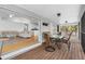 Relaxing screened patio featuring wood floors and dining table with views to the bright living room and kitchen at 79 Palm Dr, Placida, FL 33946
